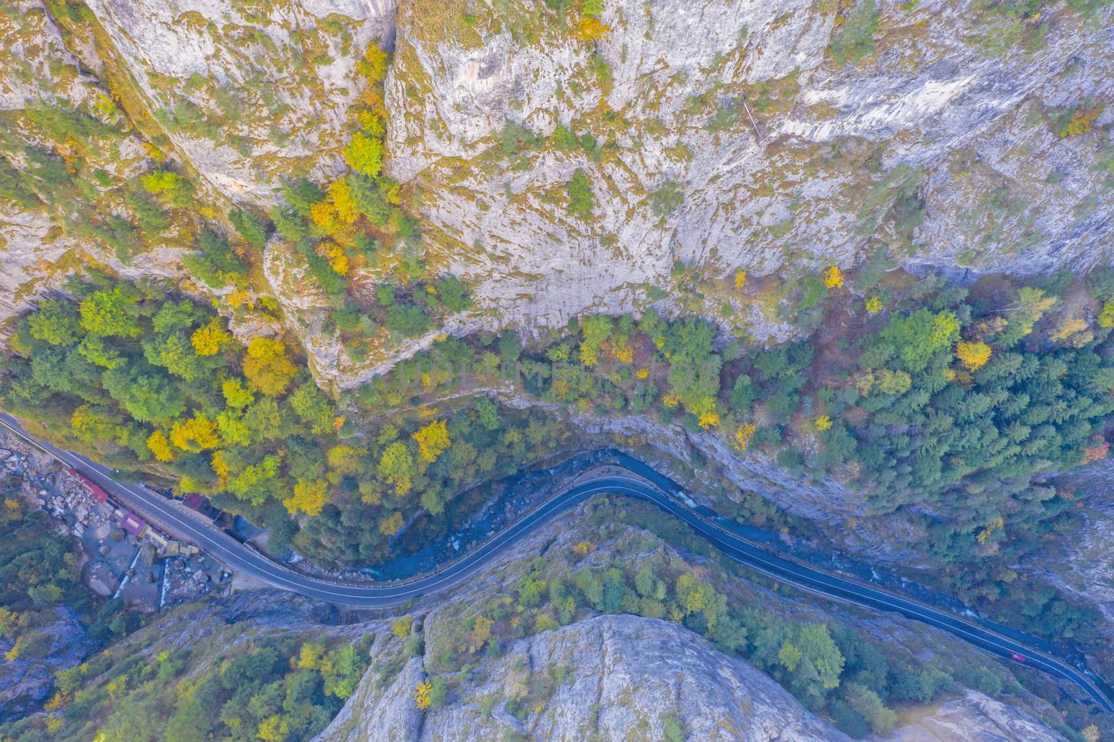 Above view of narrow gorges in autumn mountain. This stunning gorge has a part that is so narrow that it is called "The neck of Hell". The road is a passageway between Romanian provinces Moldova and Transylvania.