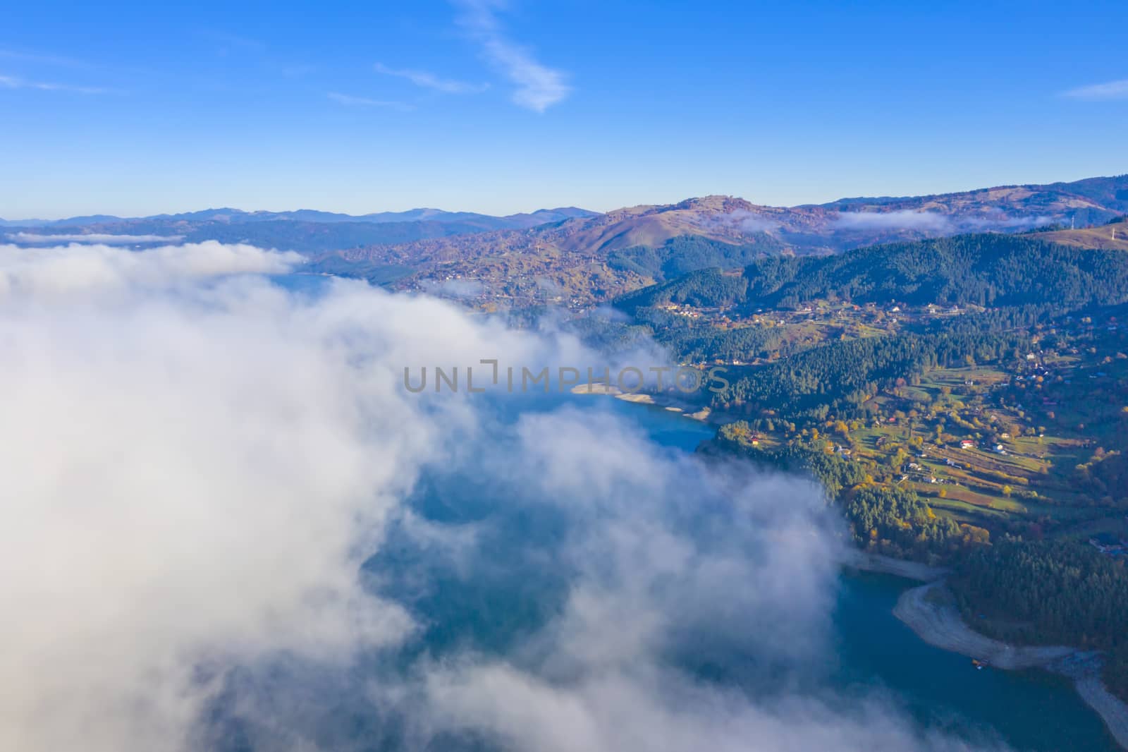 Mist cloud over the lake from above, autumn mountain landscape in Romanian Carpathians, Bicaz Lake.