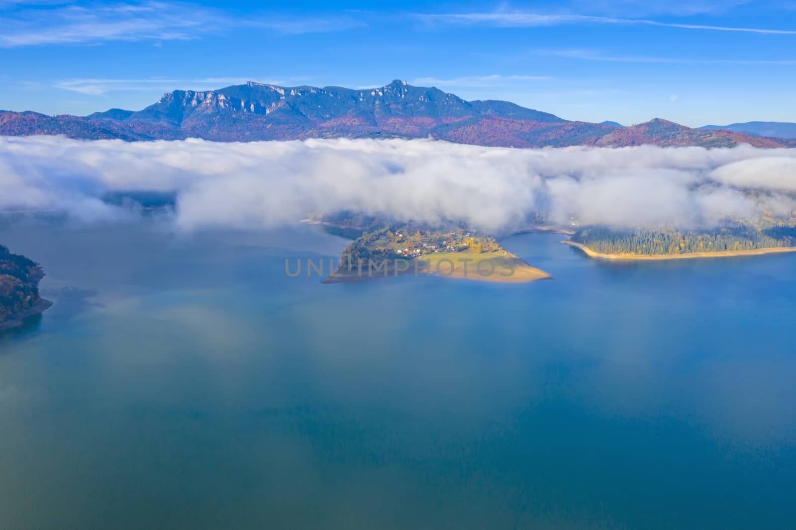 Aerial view of mist over mountain lake  and autumn forest, Romanian Carpathians scene, Bicaz Lake