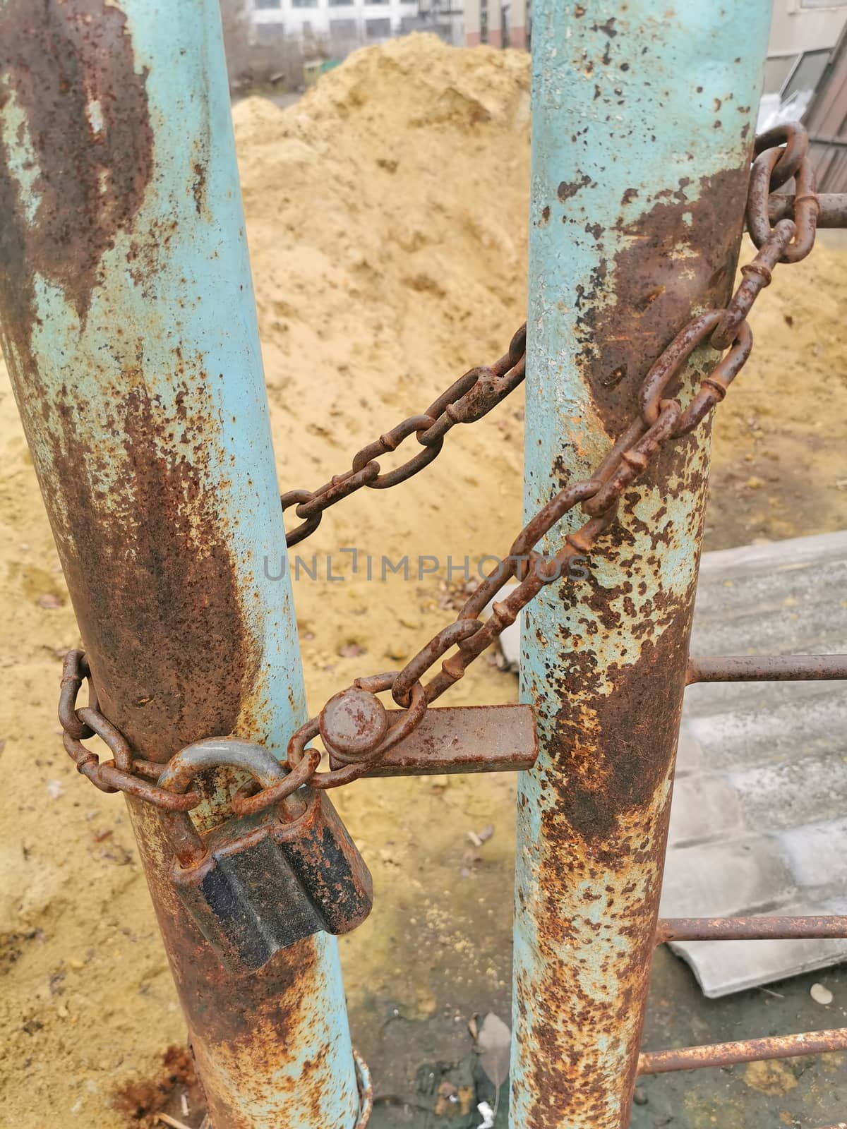 Old rusty padlock and chain at closed gates