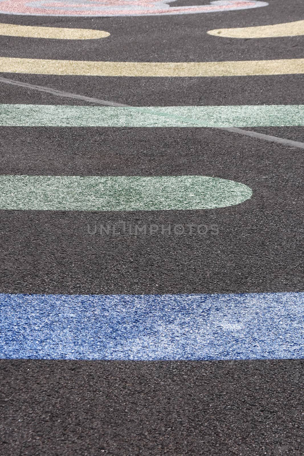 Colored line shapes on asphalt surface texture.