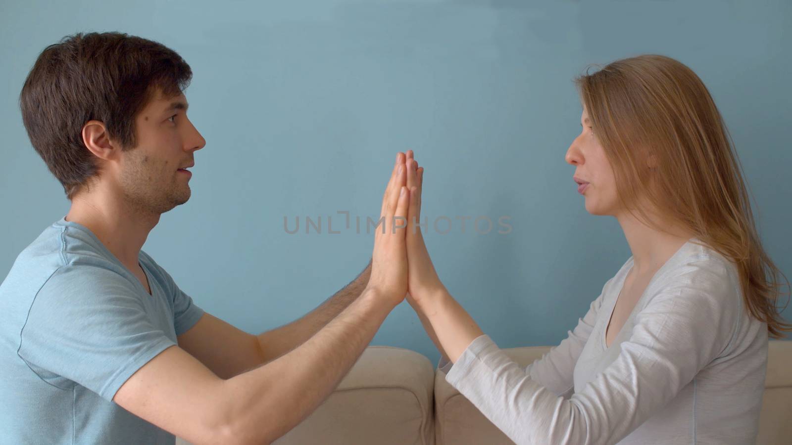 Portrait of beautiful family indoors. Husband helping his wife to relax. Couple relaxing exercise