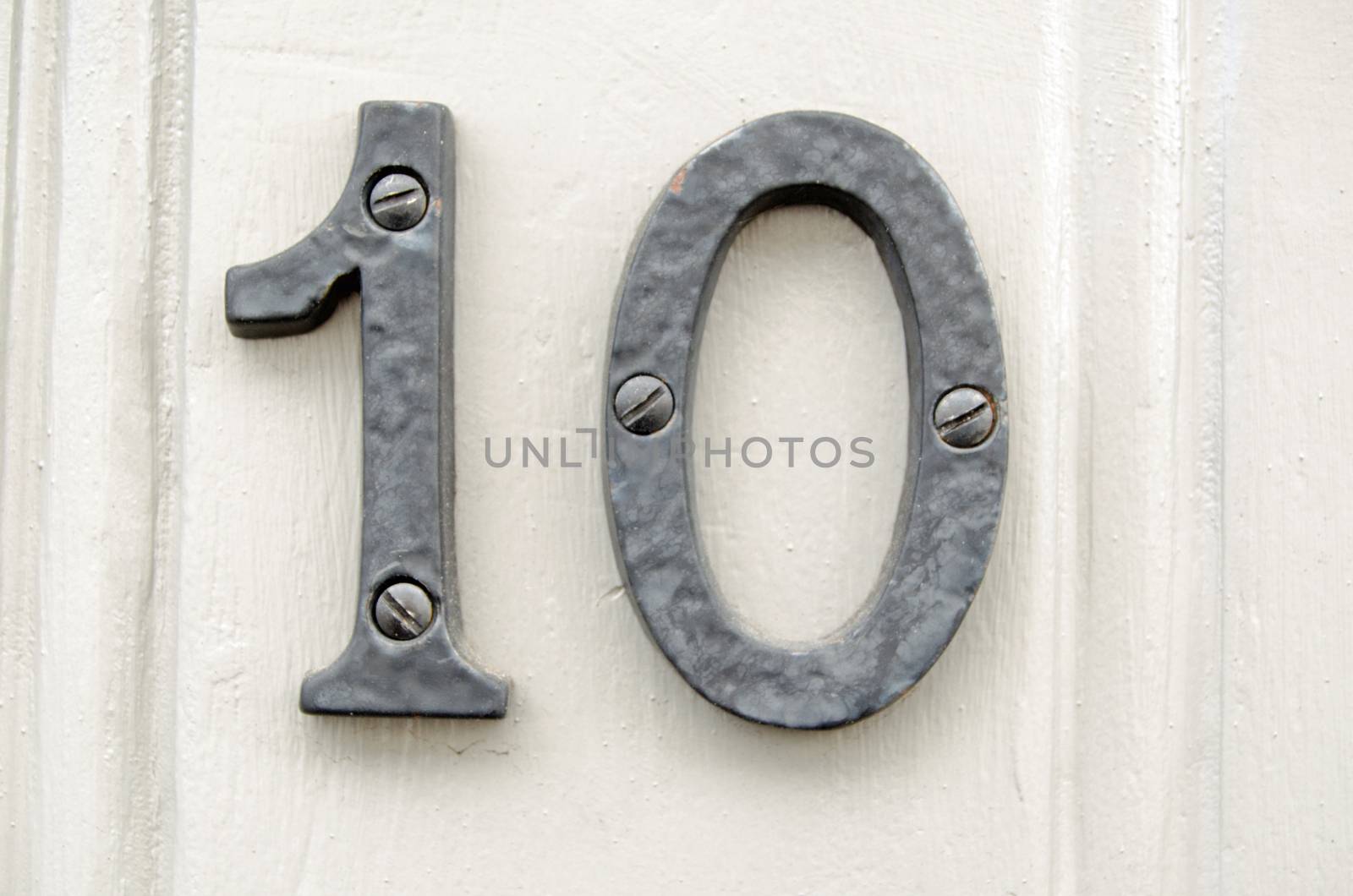 Figures representing number 10 screwed to the outside of a wooden door.