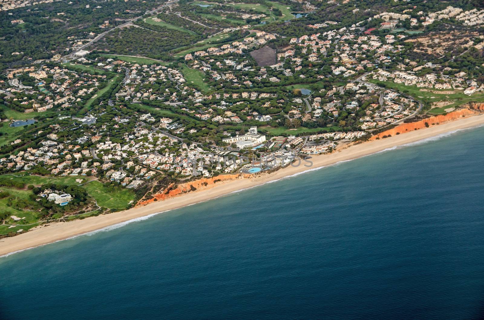 Aerial view of the coastal resort of Praia de Vale Do Lobo on the Algarve coast in Faro, Portugal.  The 5 star Dona Filipa Hotel is in the middle of the shot with golf courses and tennis courts as well as the sandy beach.