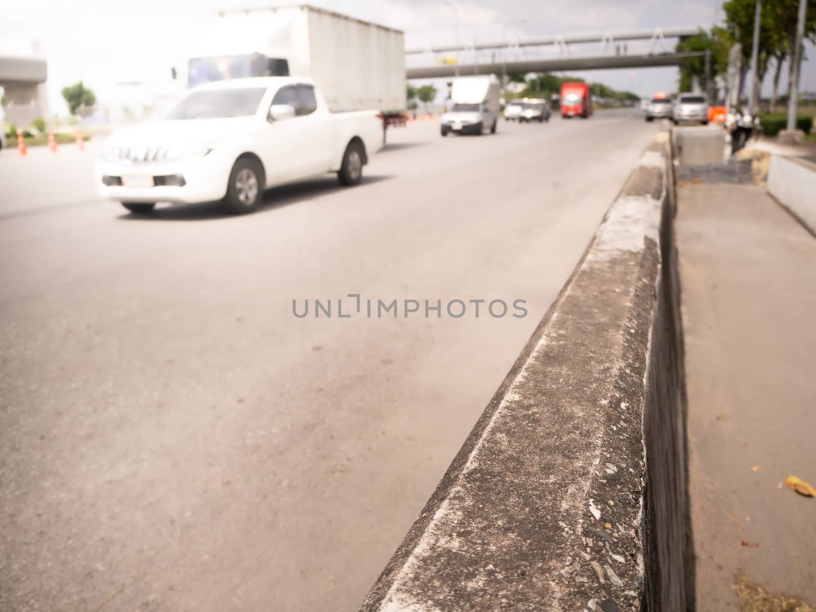 Highway traffic in sunset. Road with metal safety barrier or rail.