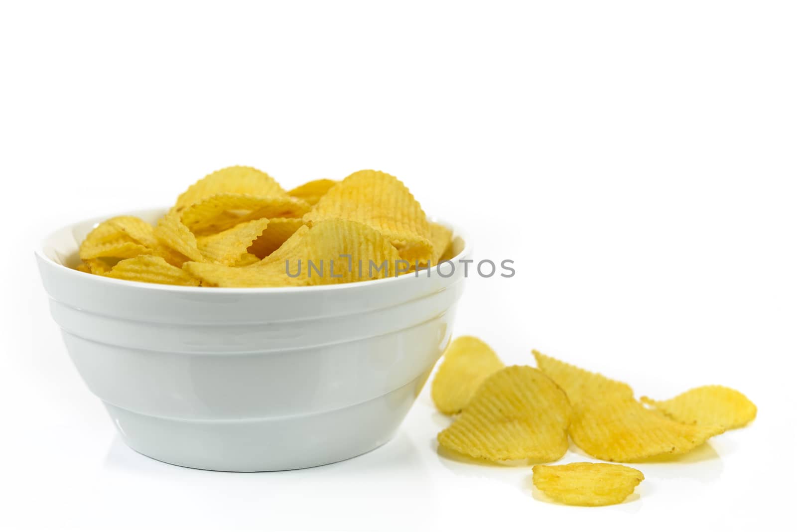 Crispy potato chips in a bowl isolated on a white background.