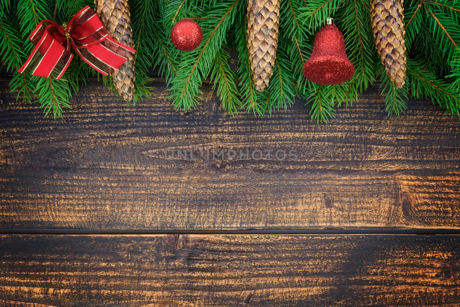 Christmas decoration concept - spruce branches with cones and Christmas ornaments on an old wooden vintage planks with copy space ( high details).