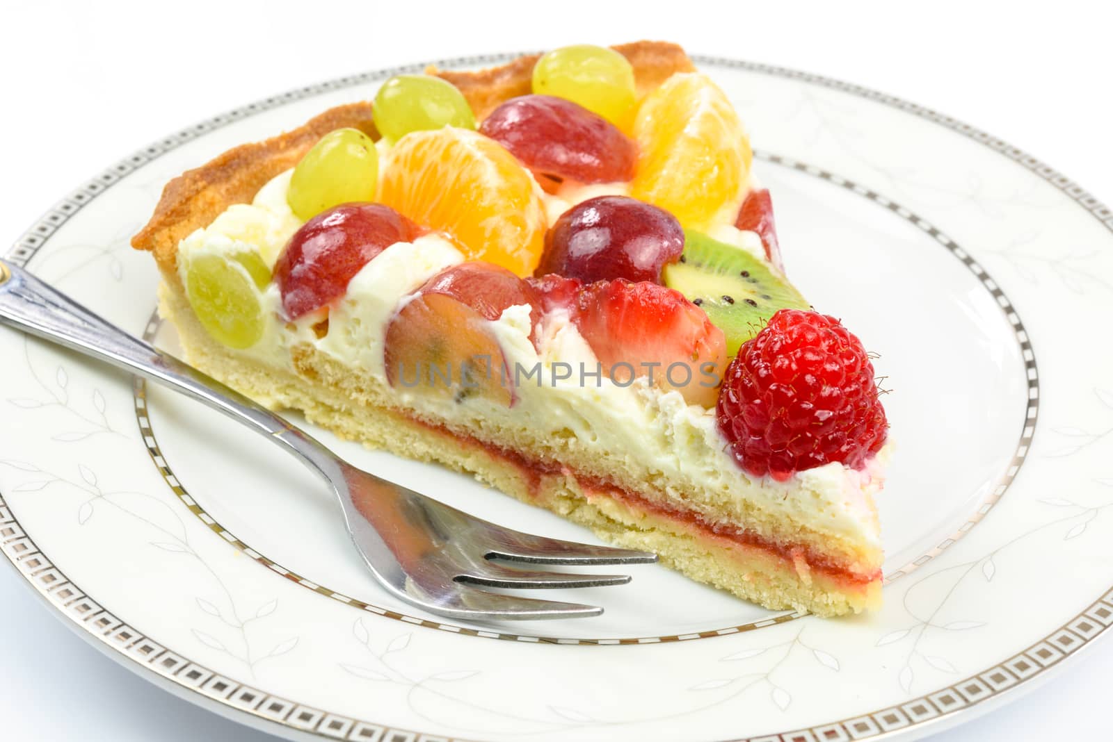 Fresh homemade multi fruit tart cake on a plate in close-up.