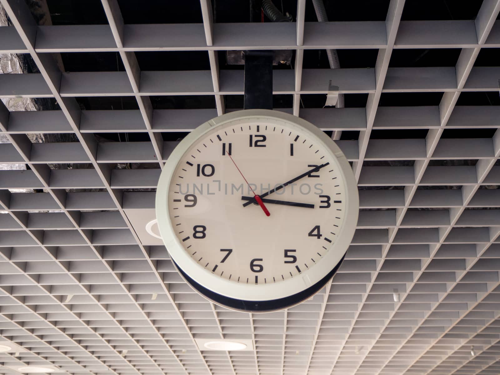 train station clock hanging from the ceiling.