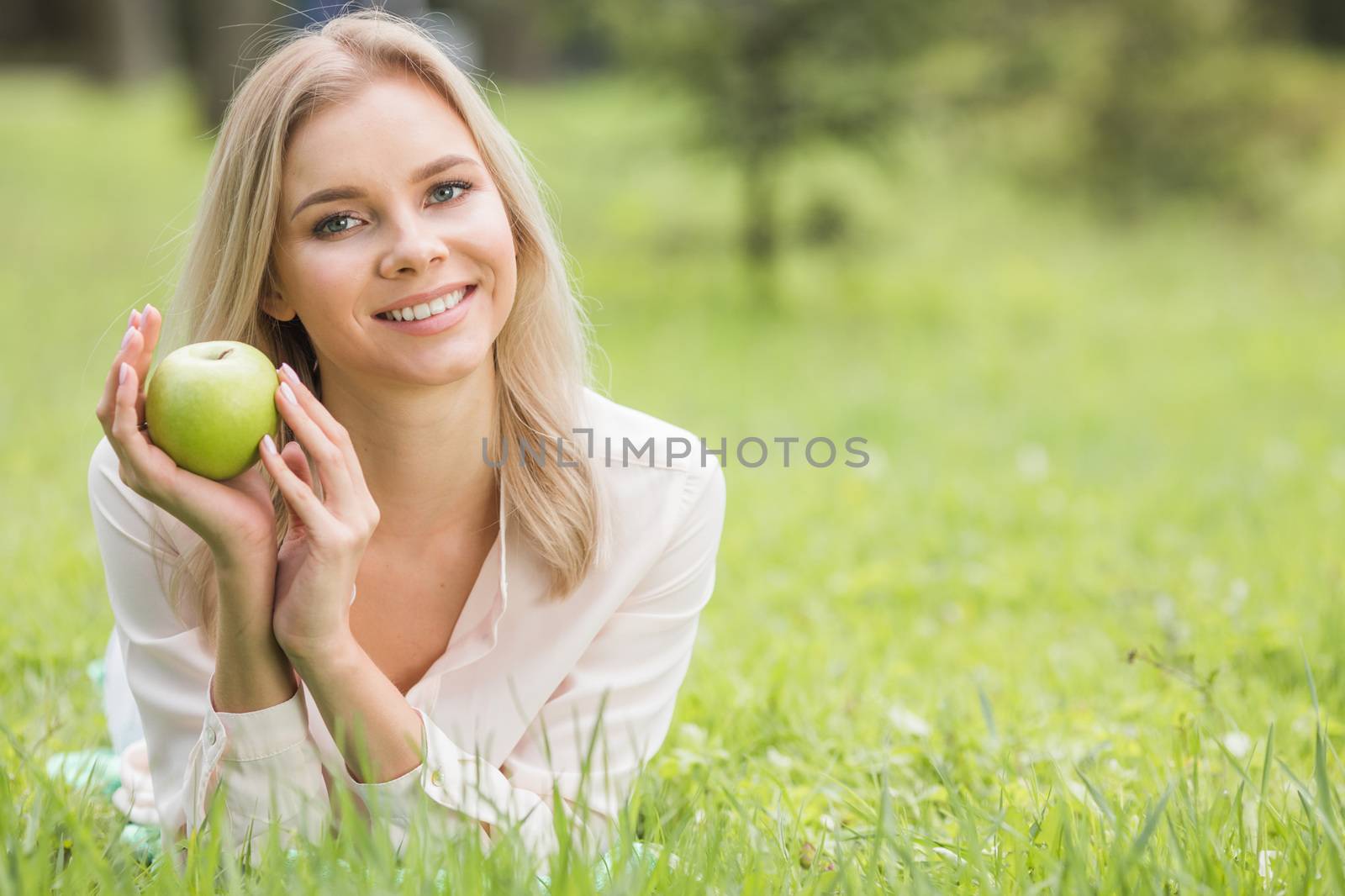 Woman with apple on grass by Yellowj