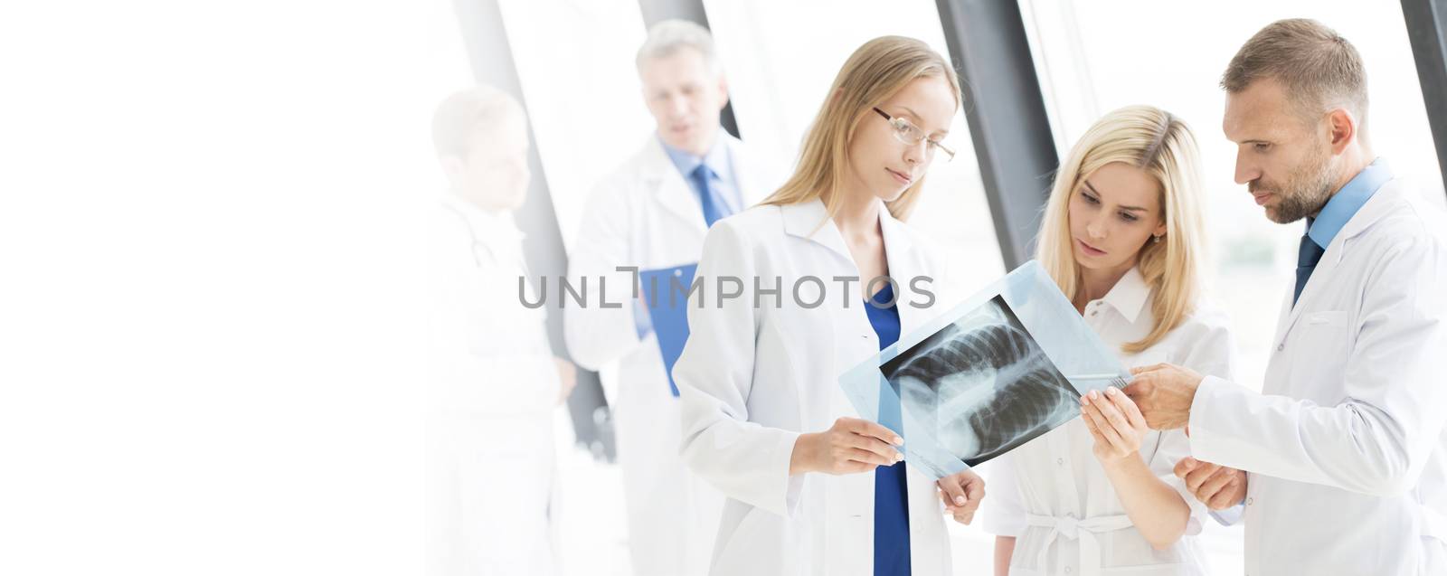 Team of experts doctors looking at MRI picture at hospital office meeting