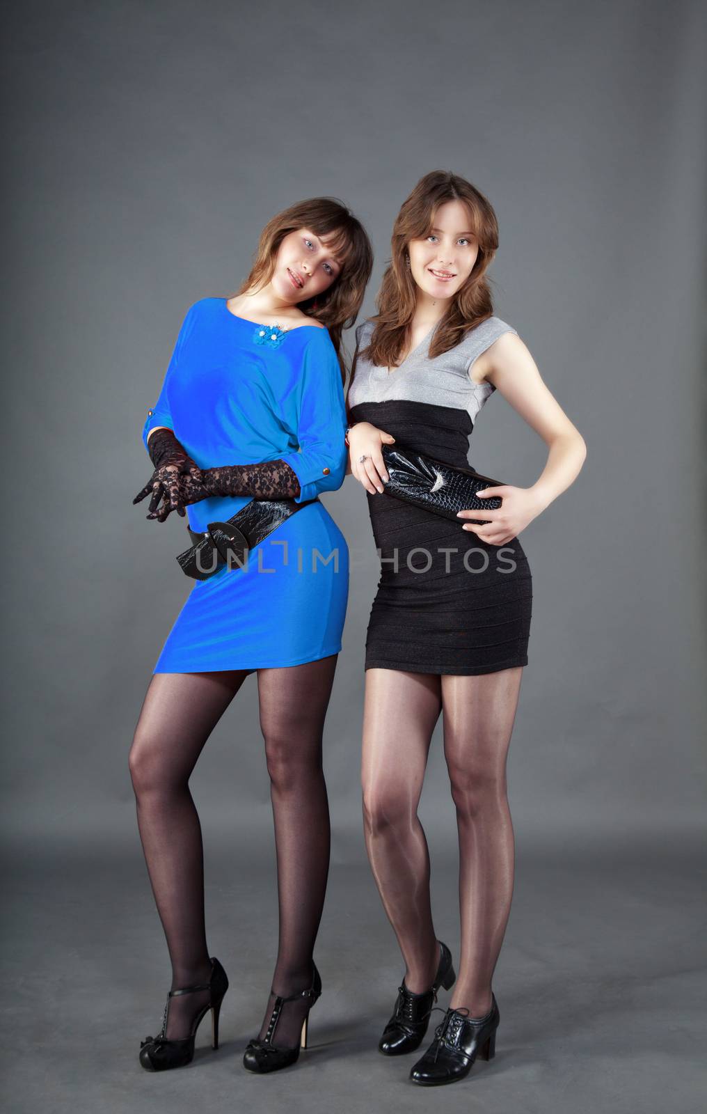 two young pretty girls posing staying in studio