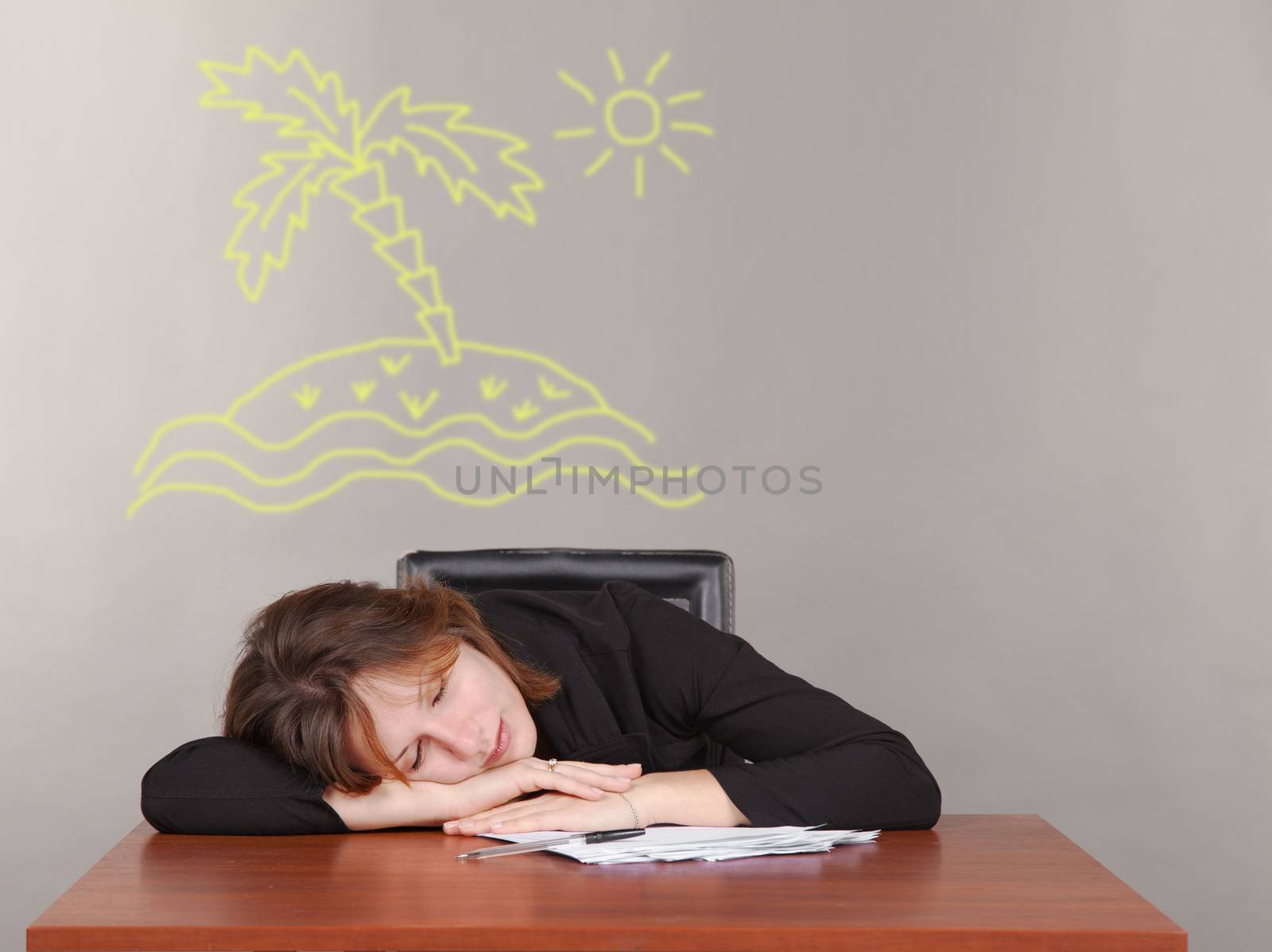 business woman sleeping at a desk and dreaming of an island with a palm tree