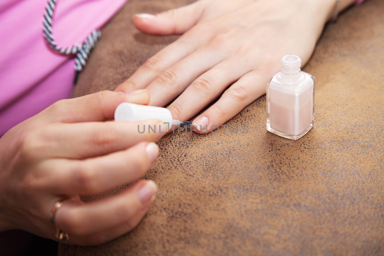woman's hand paints the nail varnish closeup