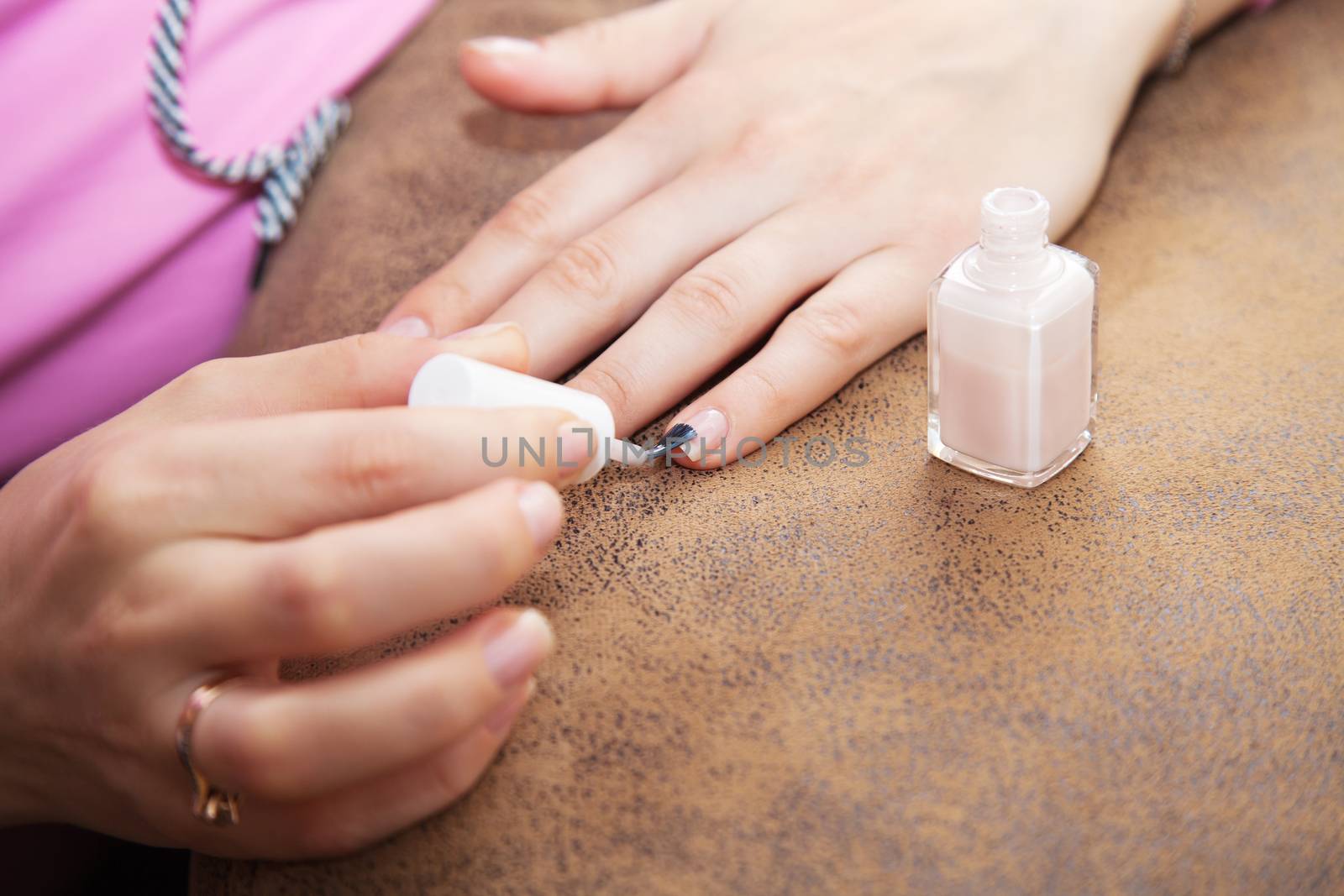 woman's hand paints the nail varnish closeup