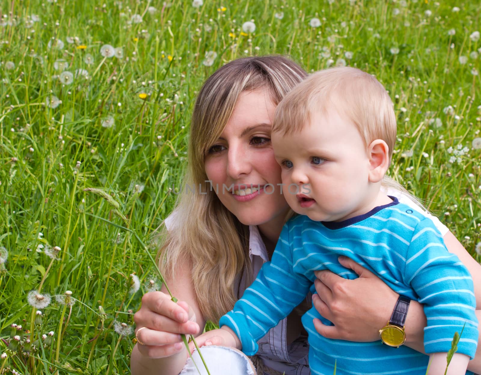 young mother with her son on the green grass