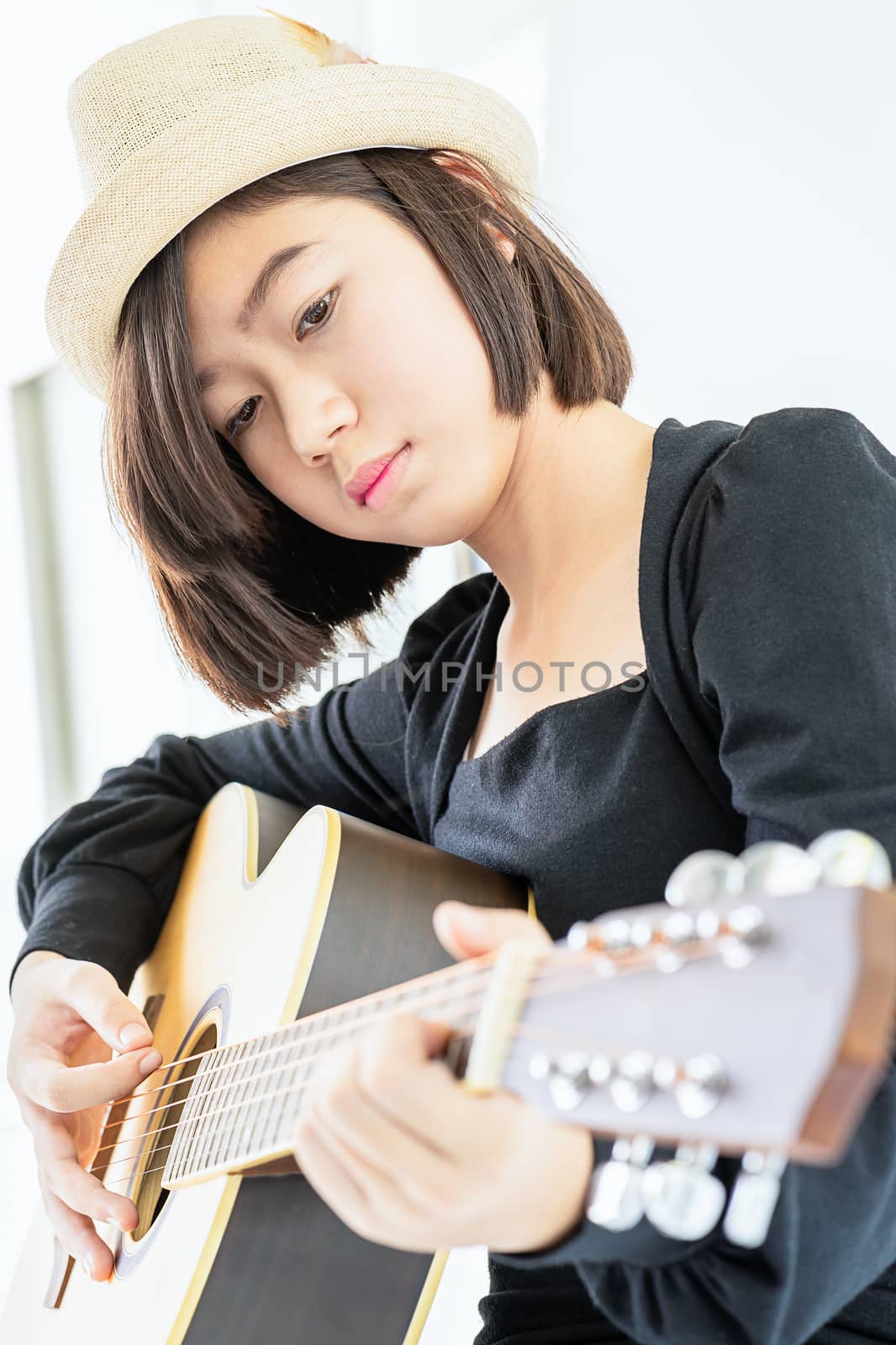 Close up Woman wear hat and playing guitar