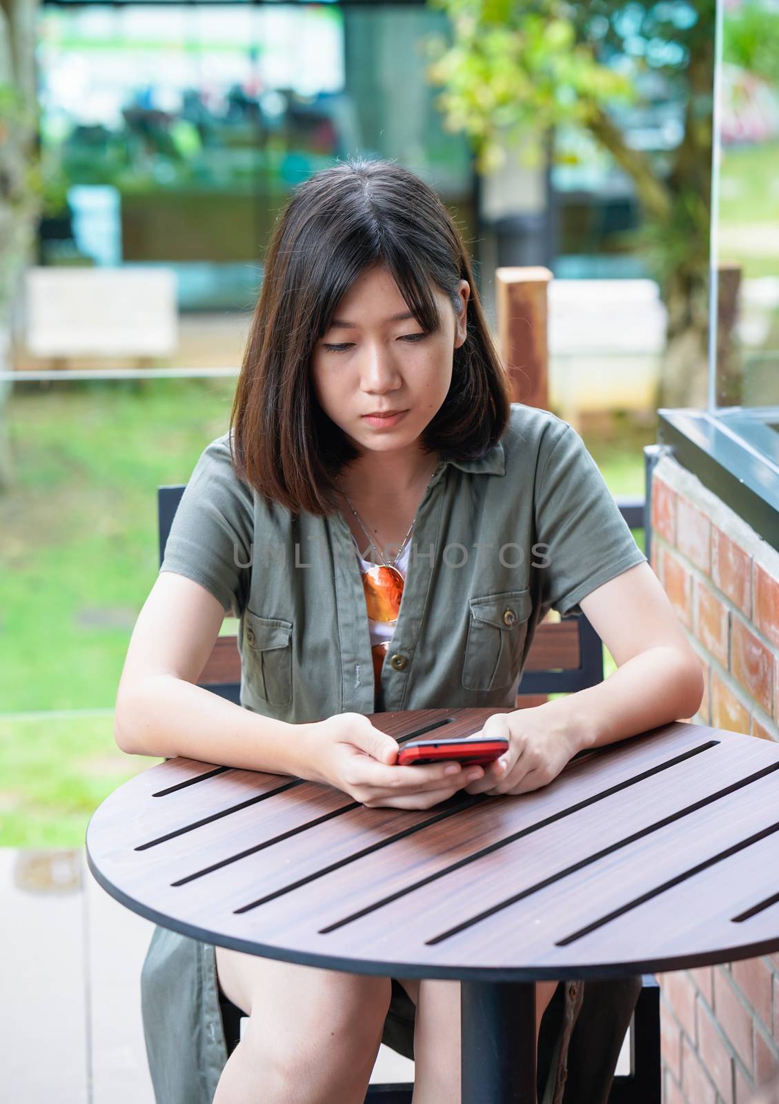 Pretty woman sitting in a cafe terrace use smartphone