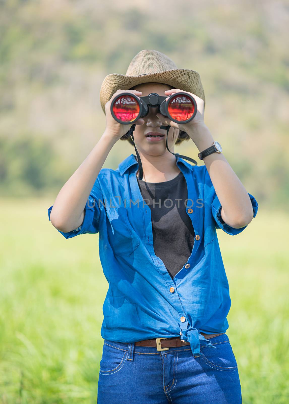 Woman wear hat and hold binocular in grass field by stoonn