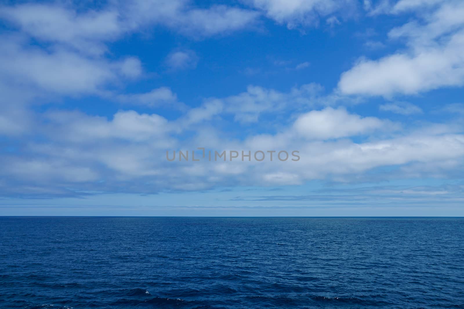 The blue water of the Atlantic Ocean with cloudy skies for use as a background.