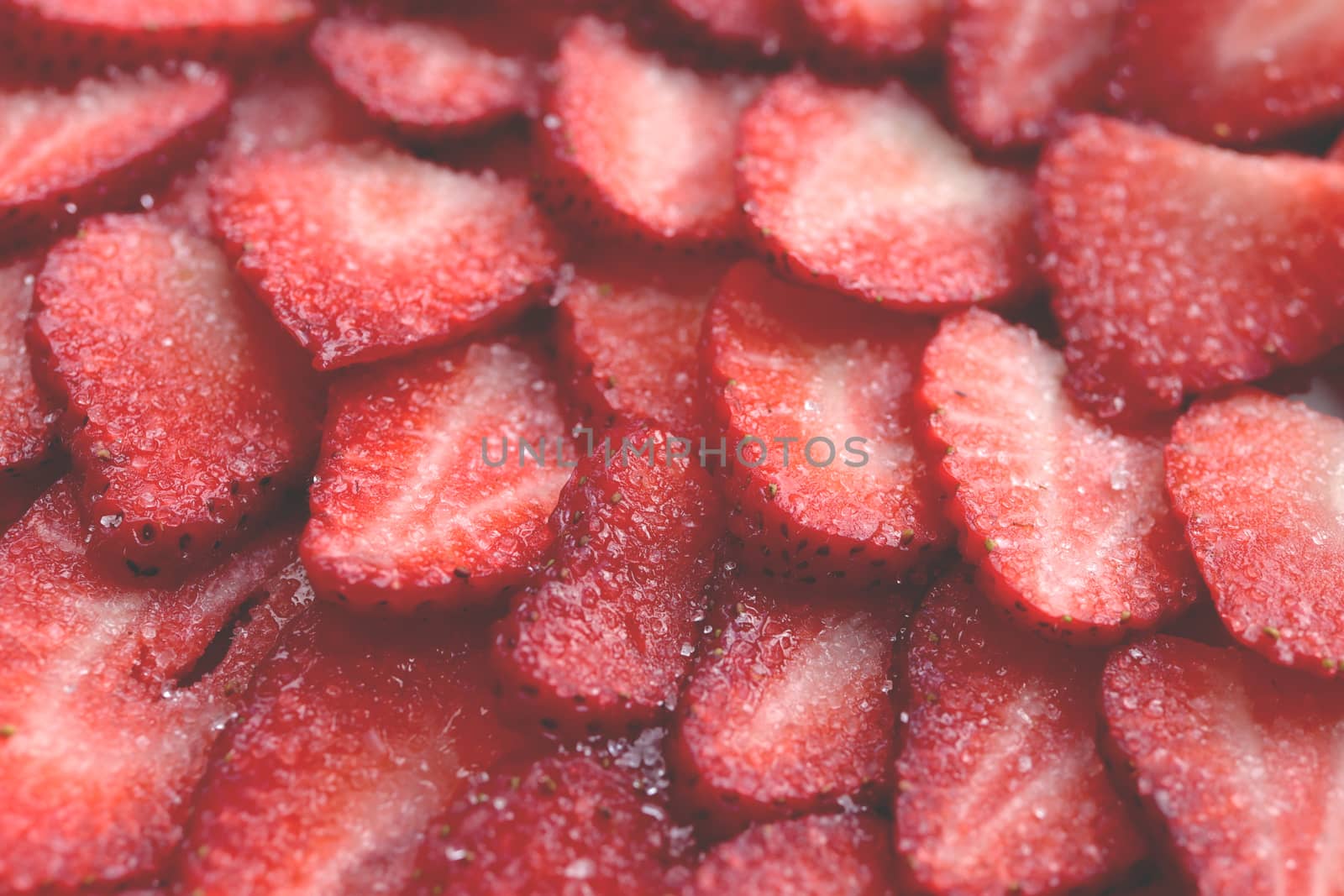 Sliced strawberry in sugar filling background. Red healthy tasty strawberry’s with sugar texture. Fresh vitamin berry backdrop.