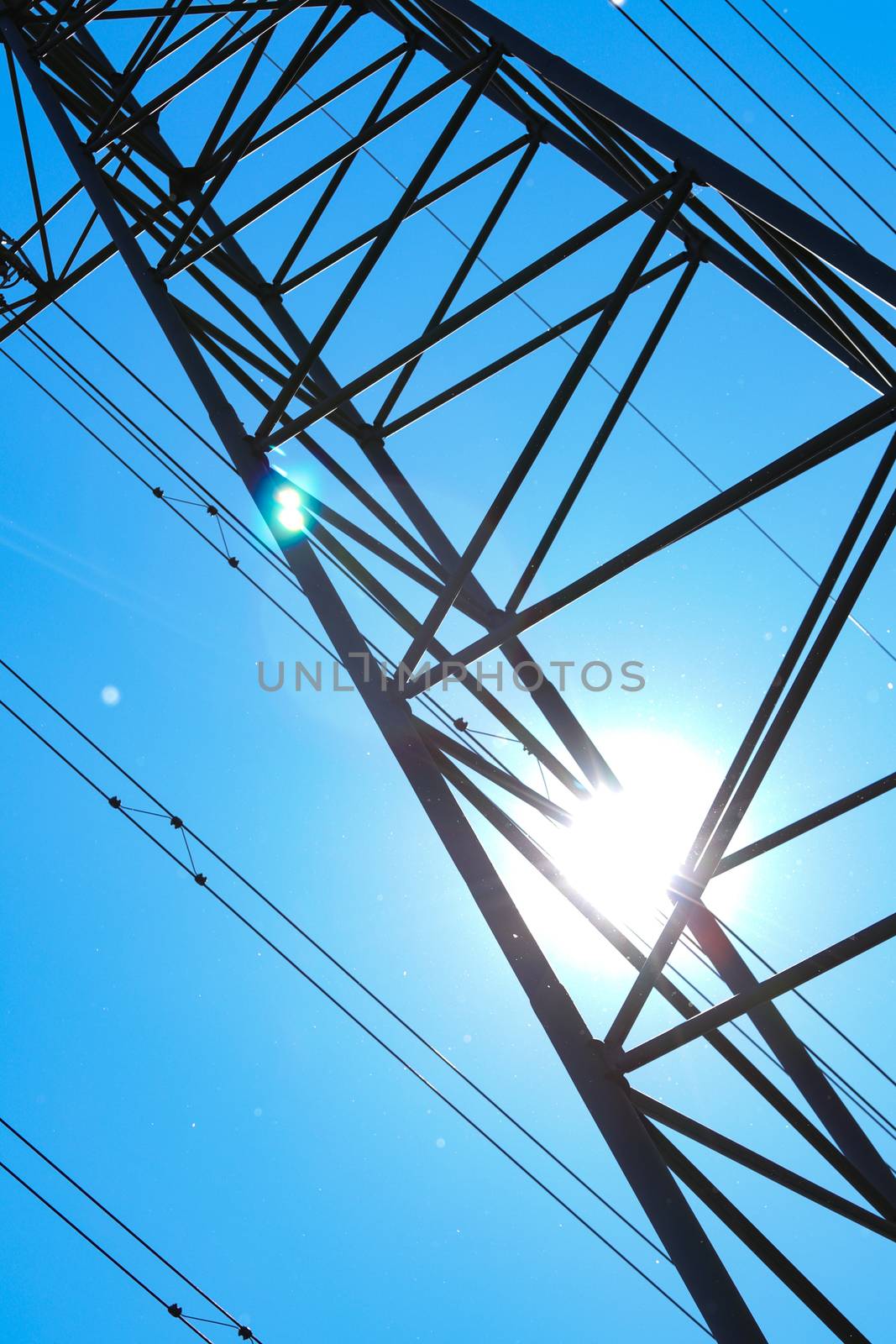 electricity pylons from low angle with blue sky by PeterHofstetter