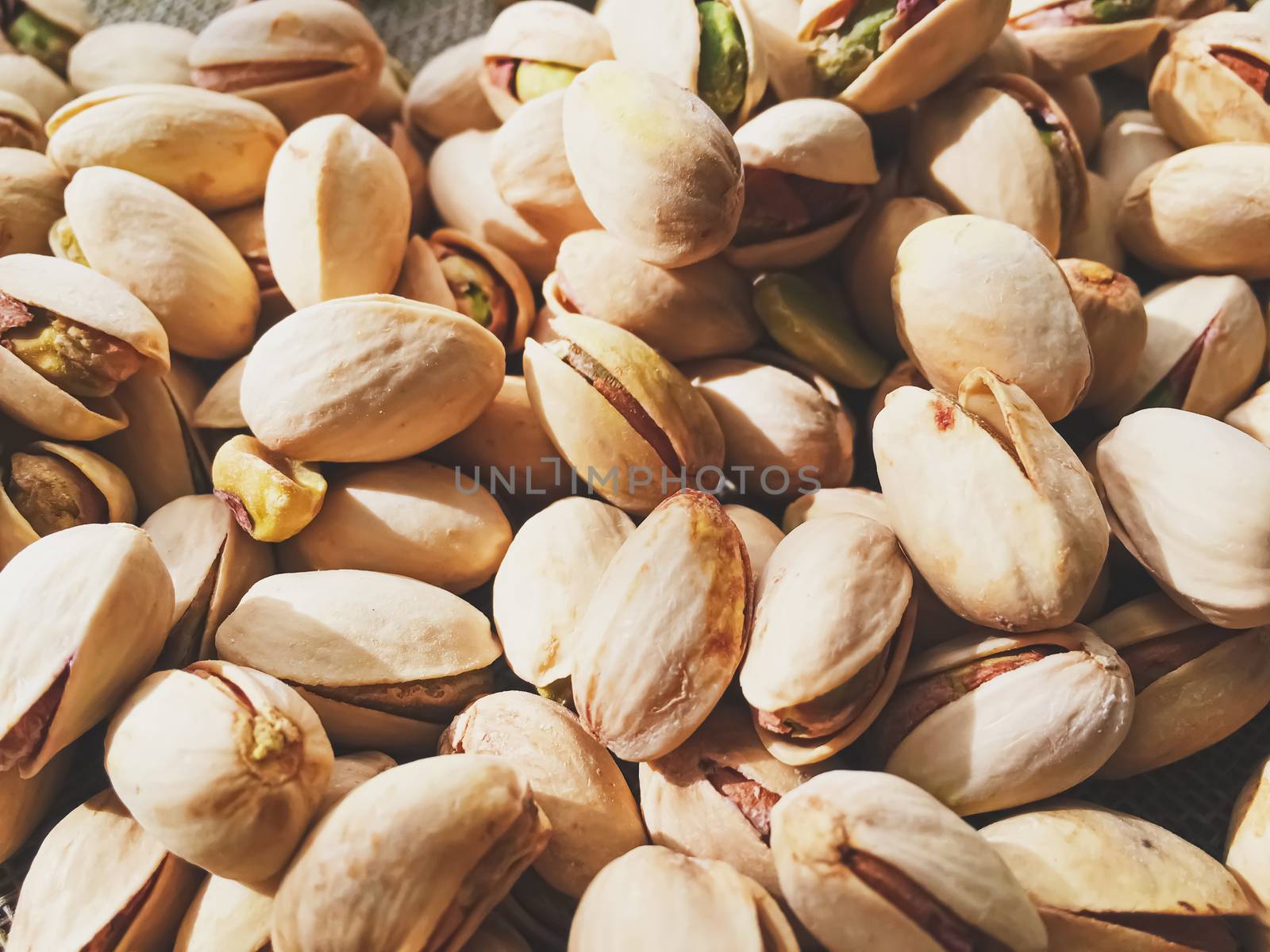 Pistachio nuts on rustic linen background, food and nutrition