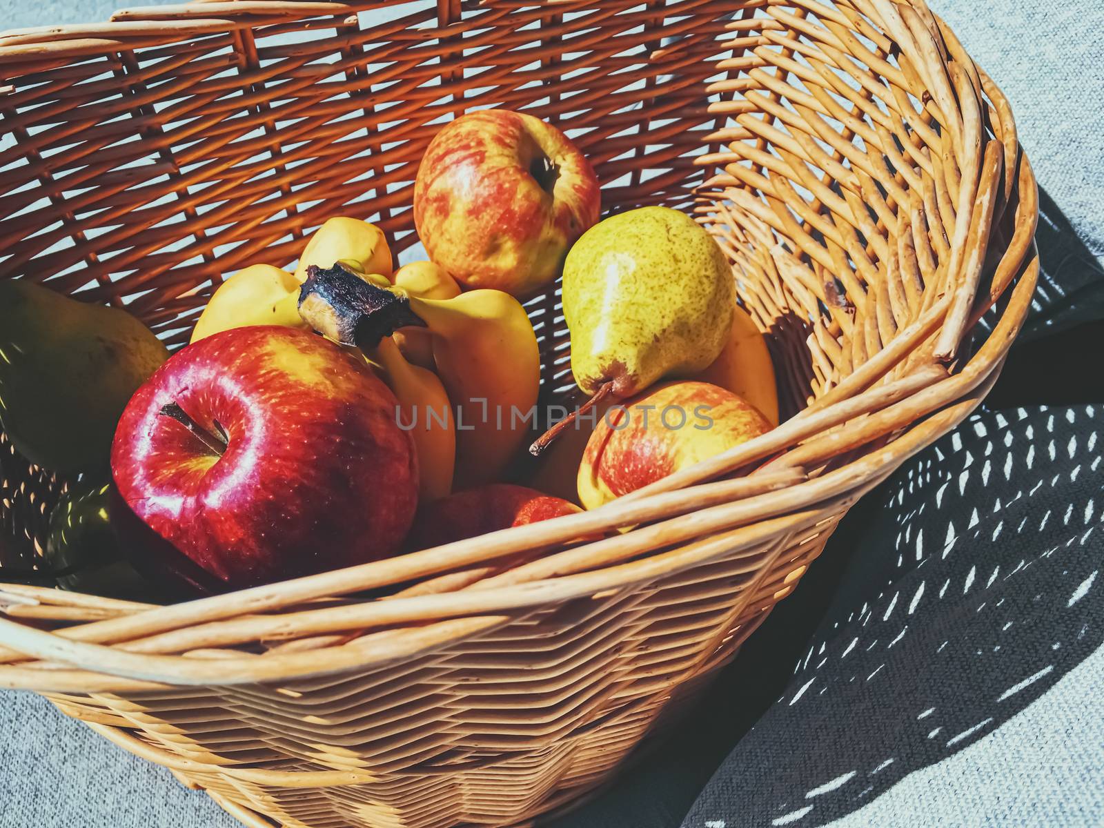 Organic apples, pears and bananas on rustic in a wicker basket, fruits farming and agriculture