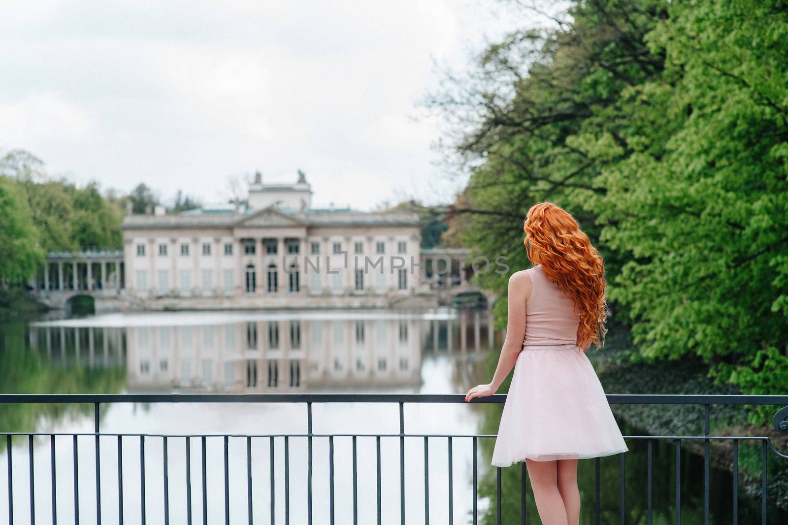 red-haired young girl walking in a park between trees by Andreua