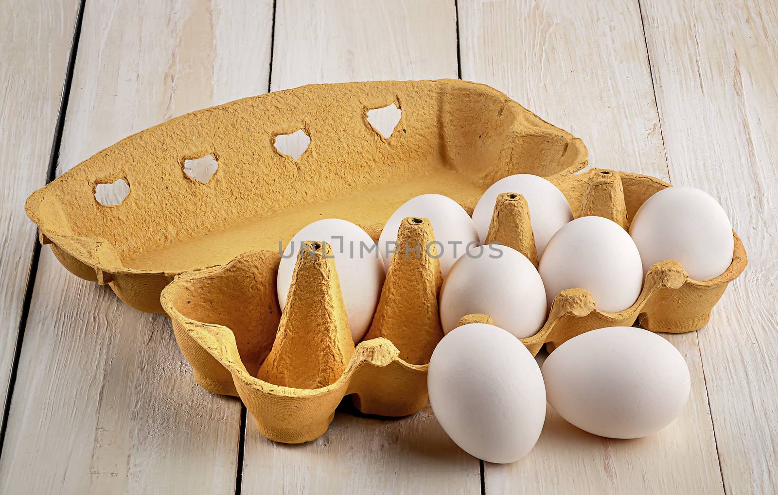 White eggs near paper tray on white table