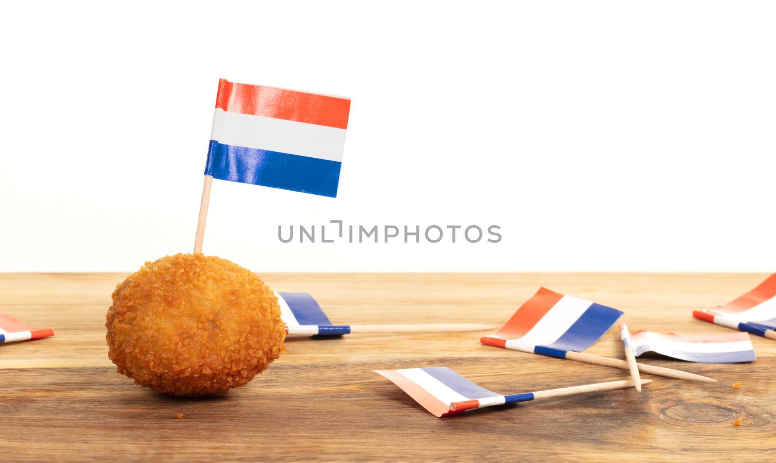 Dutch traditional snack bitterbal, just one left on a wooden serving board, isolated