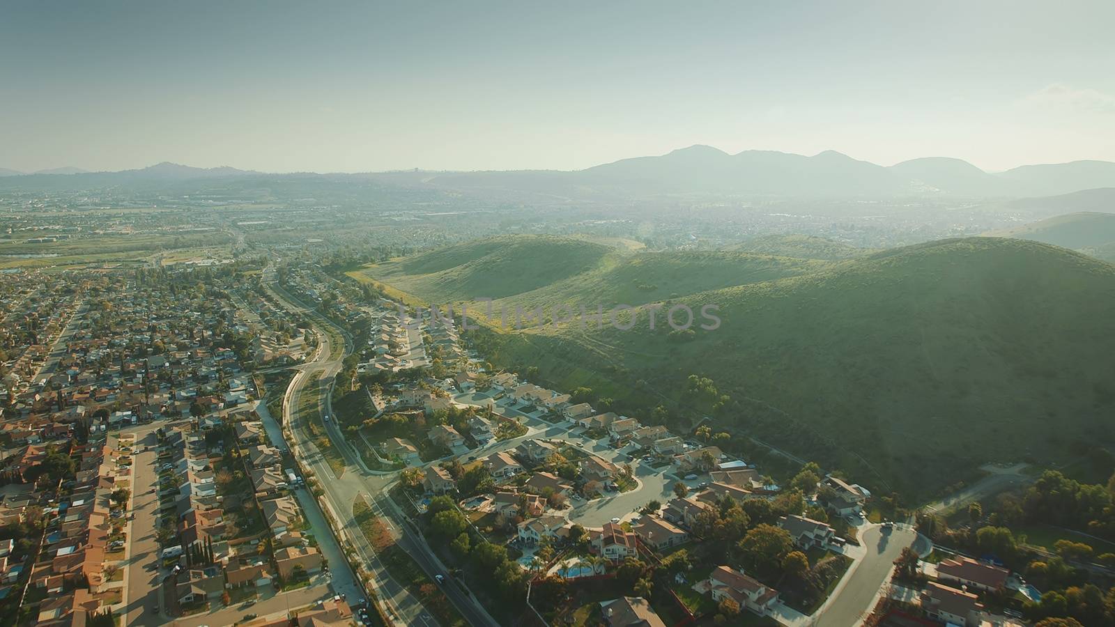 Aerial Flying over California Suburb. Aerial Landscape View For City and Mountain.