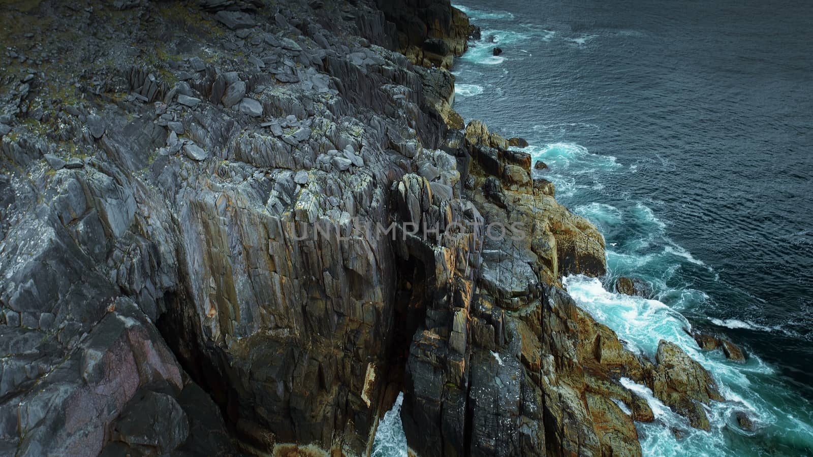 Tilt Up Along Ireland Coast - Waves Crashing on Cliffside