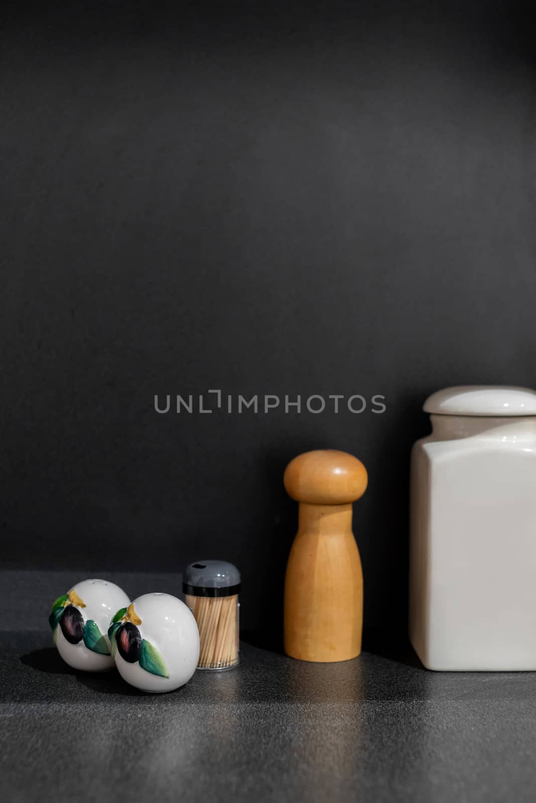 Minimalist set of spices on the kitchen counter top with black background.