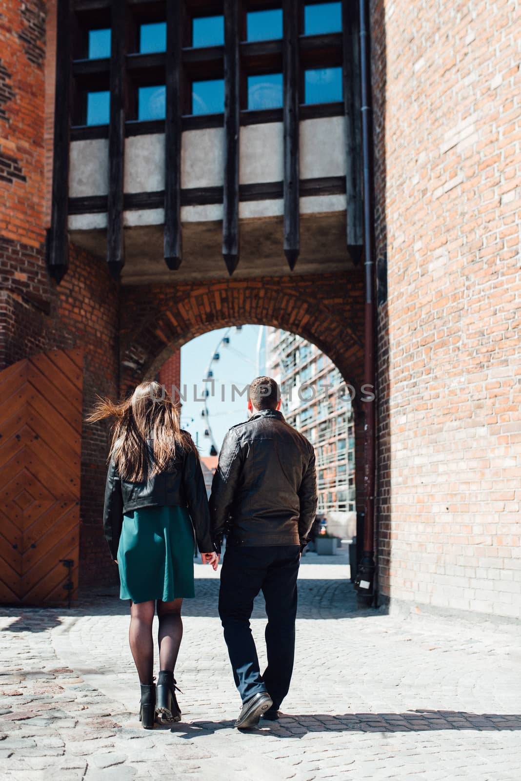 happy guy and girl walking along the tourist streets of old Europe in the city of Gdansk