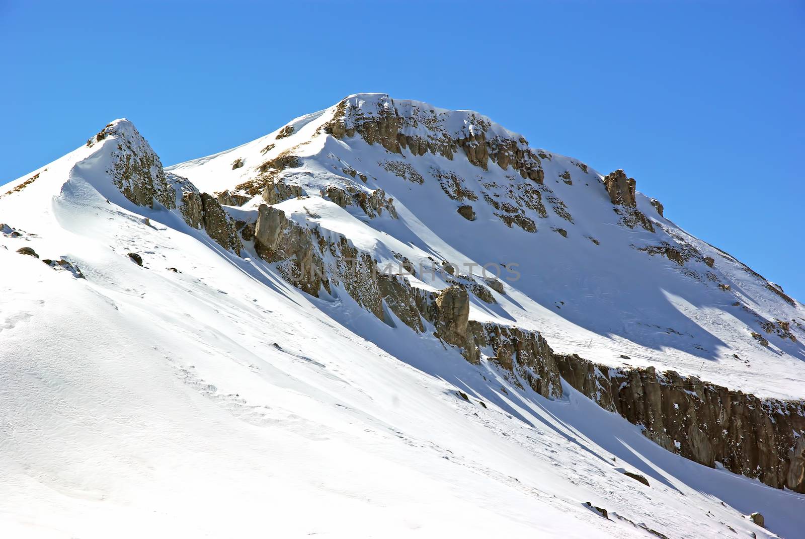 Rocky summit with snow in a beautiful winter day, Romanian Carpathians