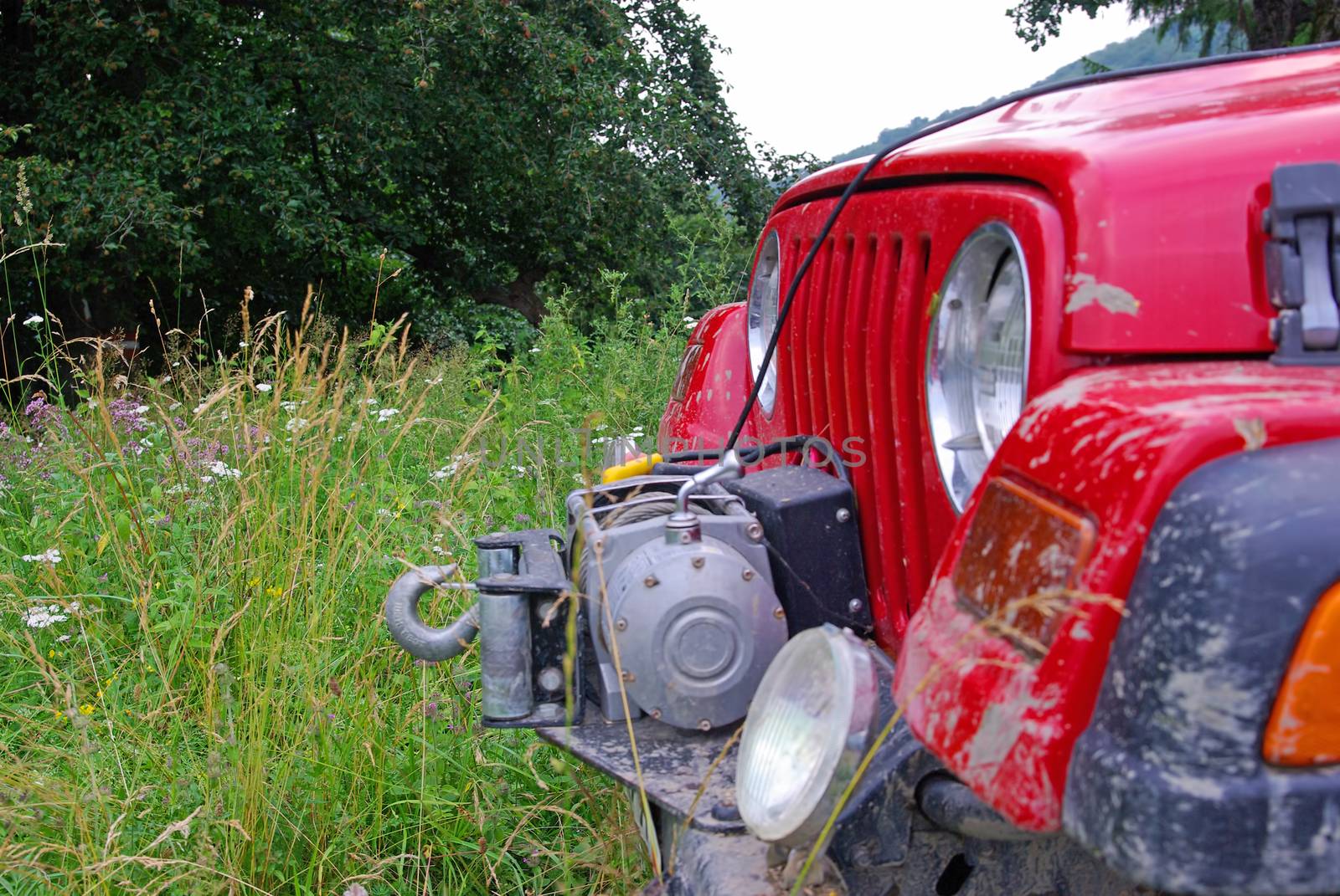 Front car of a red off road car in nature, winch equiped