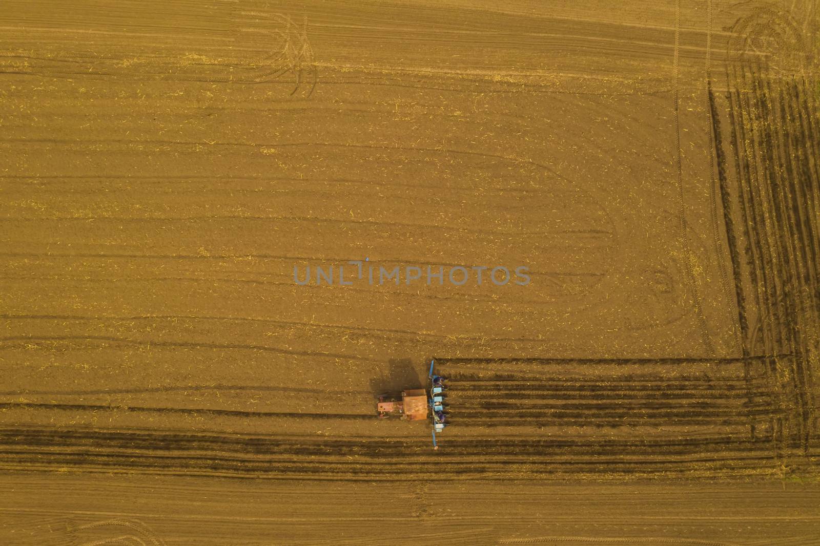 Above view of working traktor on spring field, agriculture machinery