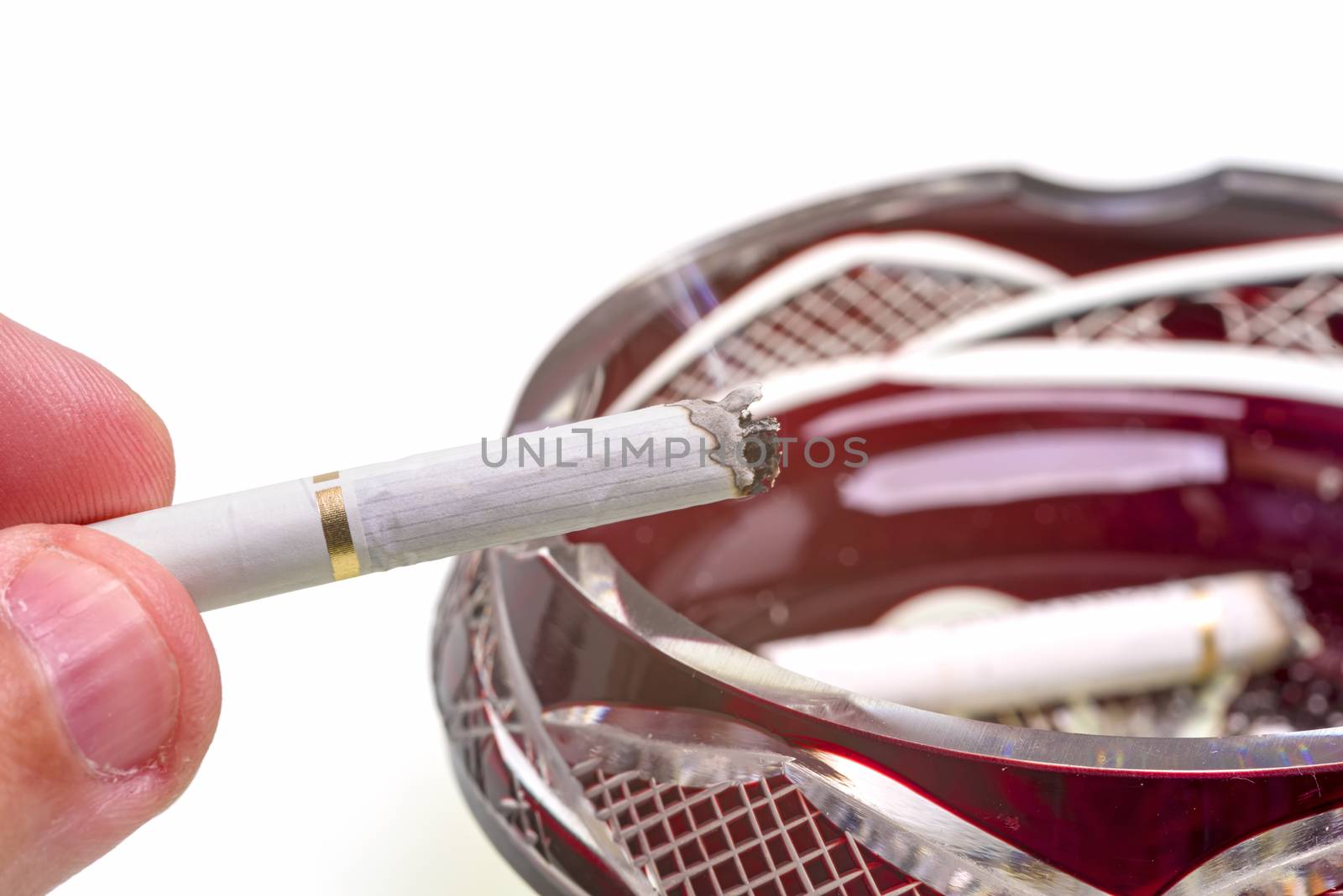 Man hand holding cigarette over ashtray