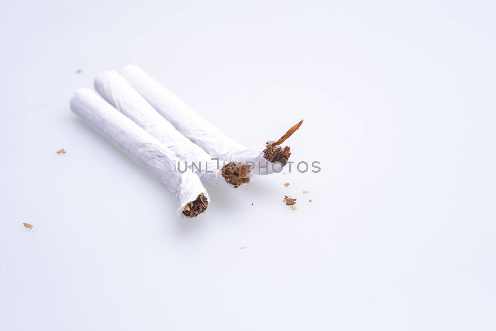 Squeezed cigarettes on the table, over a white background