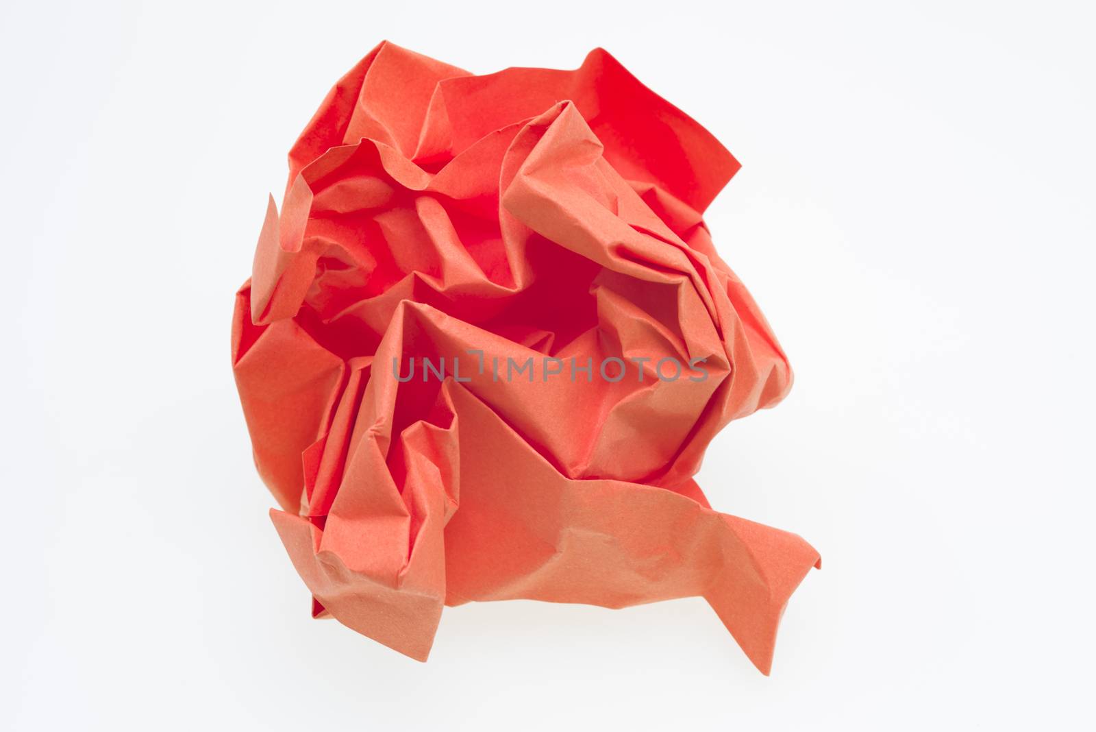Red crumpled paper ball over a white background