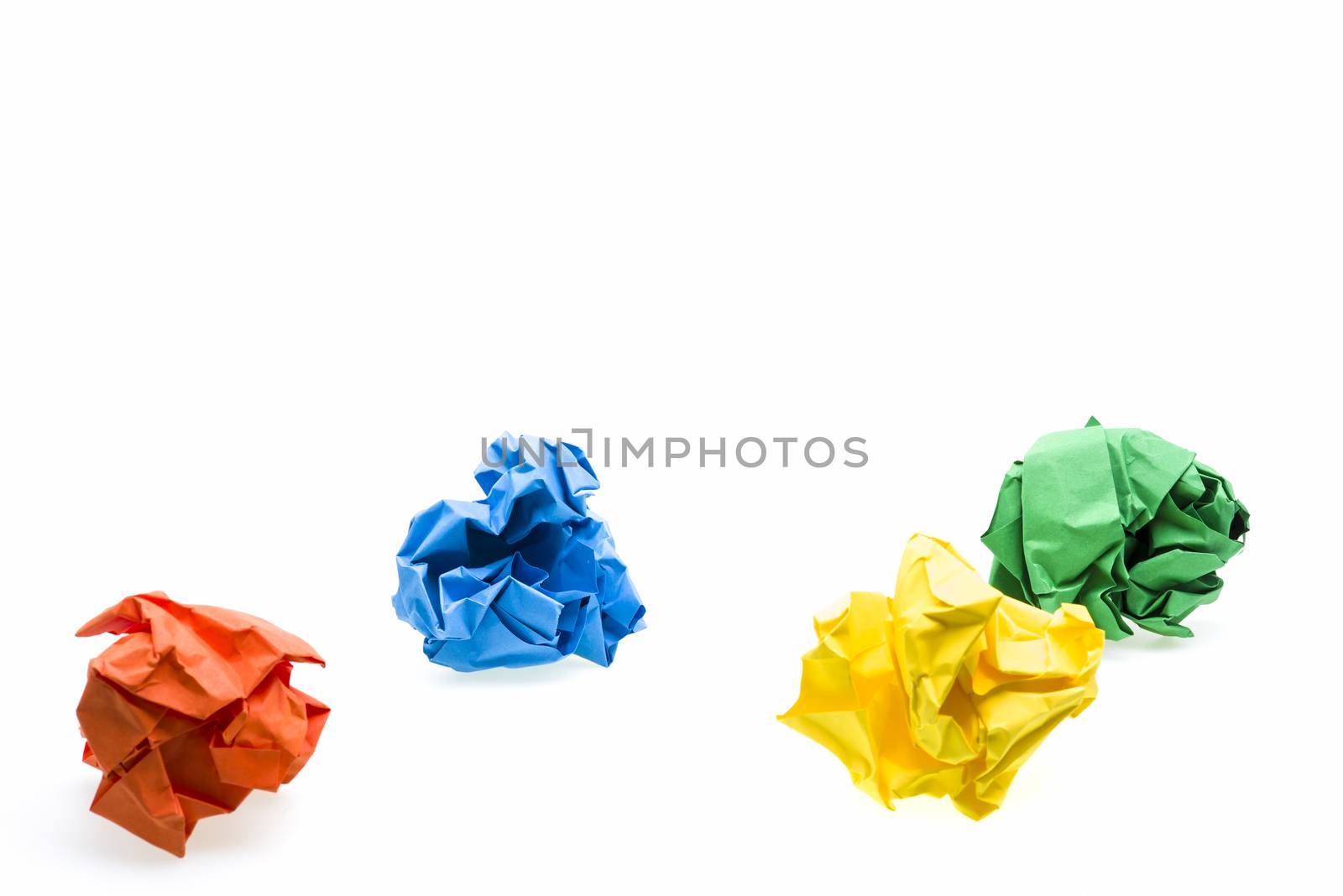Colored crumpled paper ball over white, focus on second row