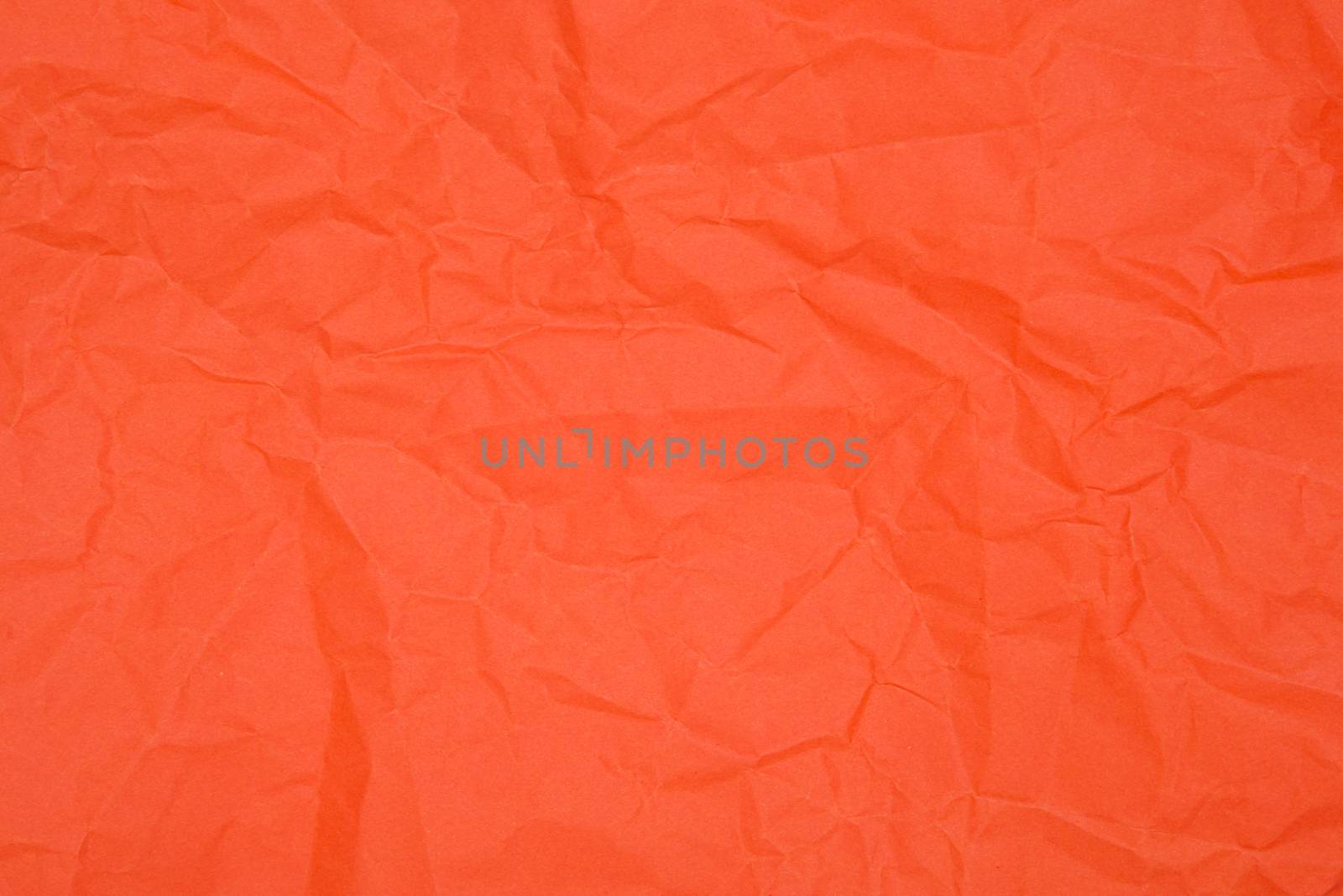 Red crumpled paper as texture, close up image