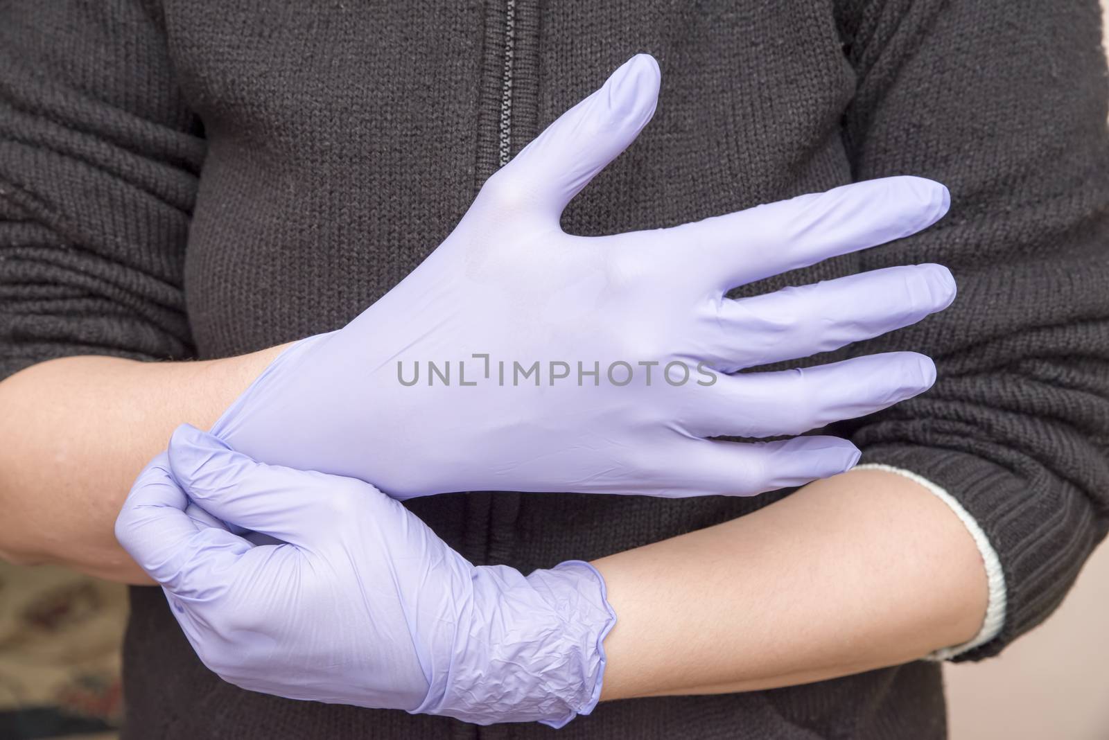 Woman hand wearing latex gloves by savcoco
