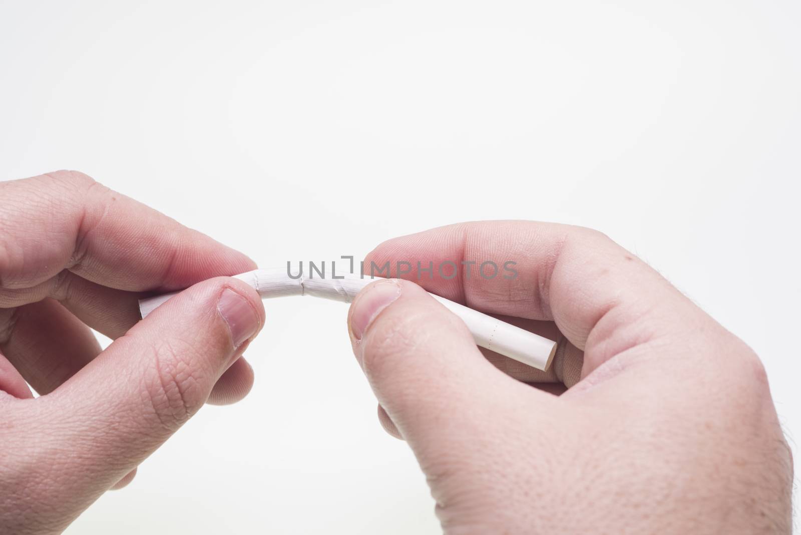 Isolated hands broke a cigarette on white background