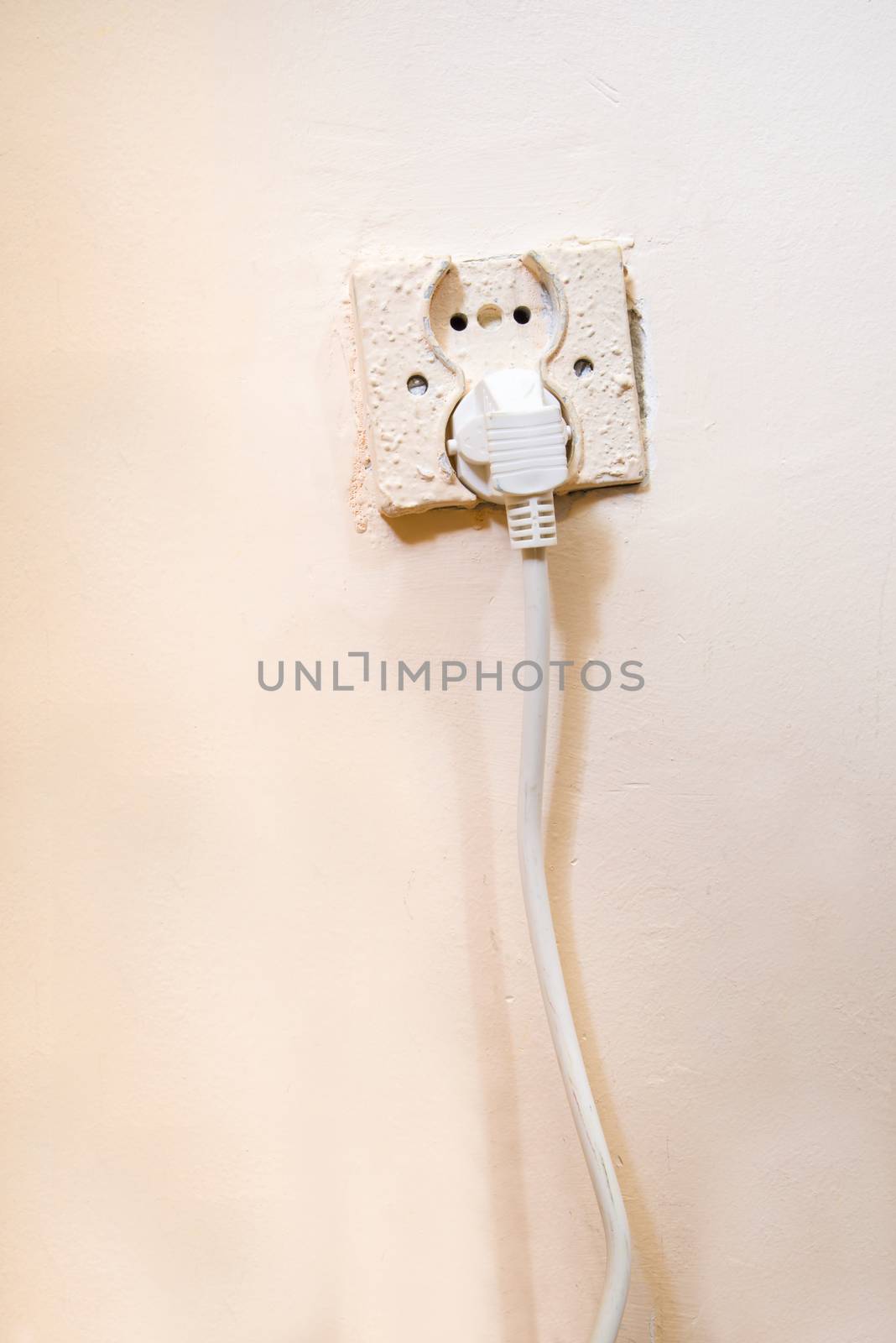 Old electrical socket with power cable pluged in
