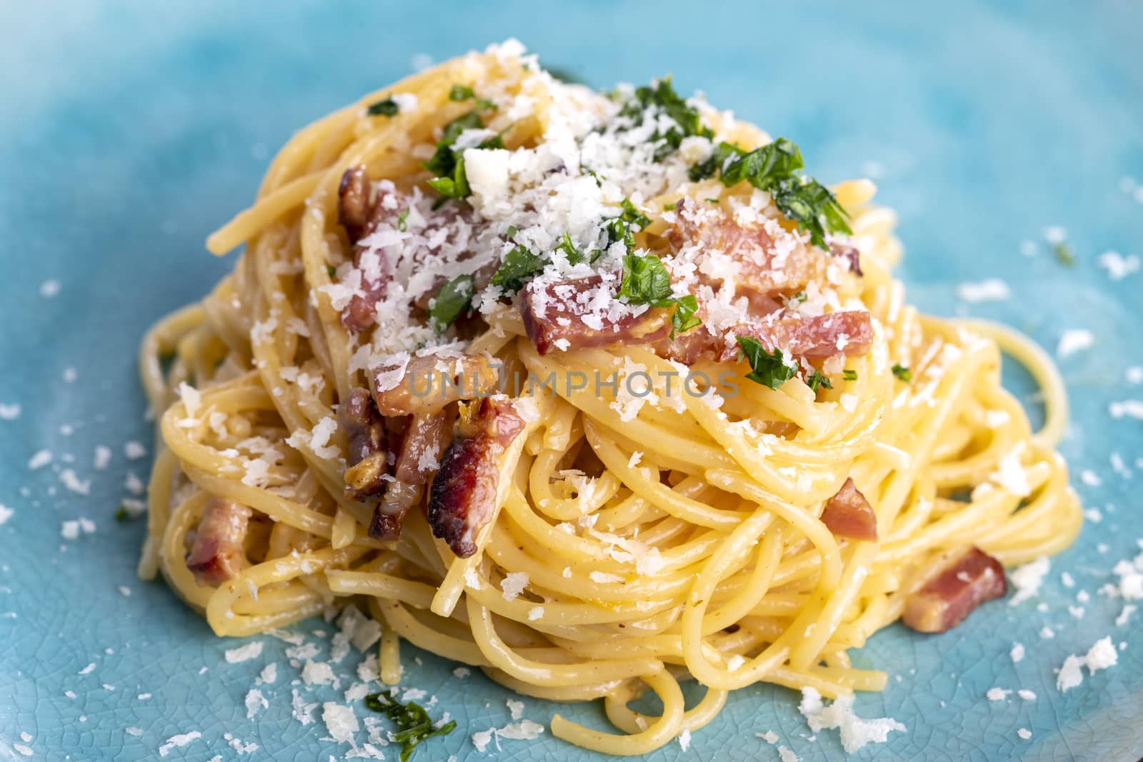 spaghetti carbonara on a blue plate by bernjuer