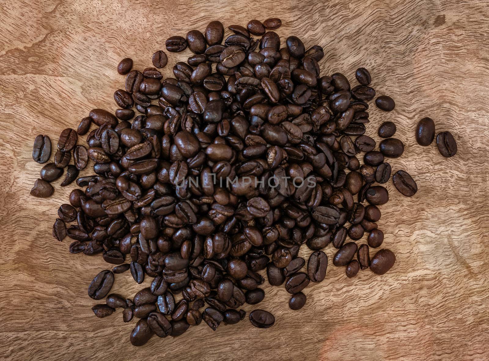 Group of roasted coffee beans on a wooden surface