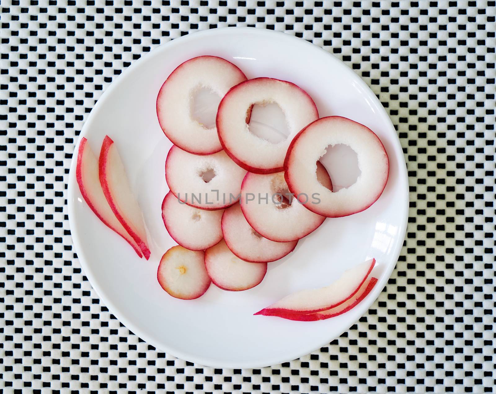 Slices of rose fruit in a plate on a white surface