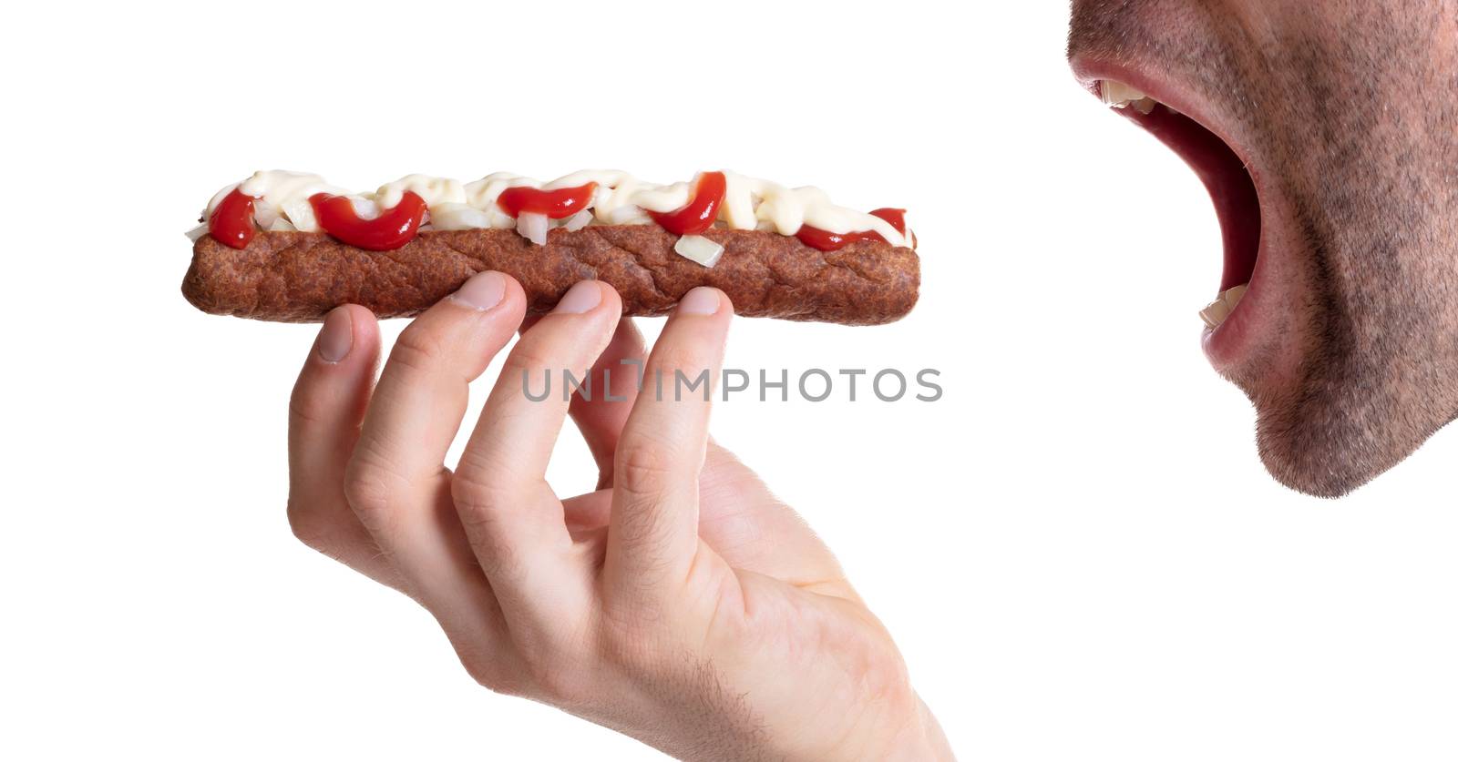 Man eating a frikadel with ketchup, mayonnaise on chopped onions, a Dutch fast food snack called 'frikadel speciaal'